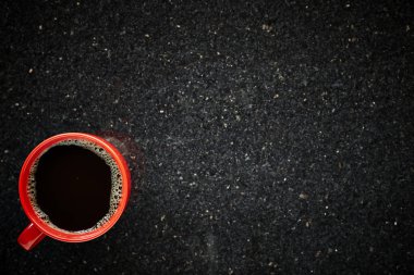 Kırmızı tablo granit arka plan üstten görünüm ile sabahı siyah kahve fincan
