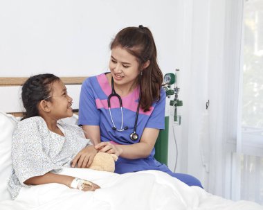 Sevgi ile bakan doktor hastane odasında küçük kız
