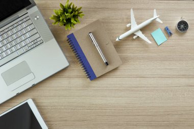 Office not defteri ve uçak, bilgisayar ve ağaç ahşap masa. kopya alanı tasarımı için en iyi manzaralı. düz lay