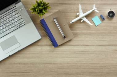Office not defteri ve uçak, bilgisayar ve ağaç ahşap masa. kopya alanı tasarımı için en iyi manzaralı. düz lay