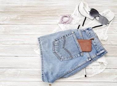 Yaz rahat tarzı. Modern kadın giysi ve aksesuarları kolaj. Güneş gözlüğü, kolsuz bluz ve kot pantolon. Düz yatıyordu, en iyi görünümü