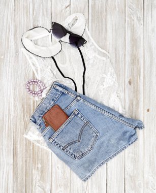 Yaz rahat tarzı. Modern kadın giysi ve aksesuarları kolaj. Güneş gözlüğü, kolsuz bluz ve kot pantolon. Düz yatıyordu, en iyi görünümü