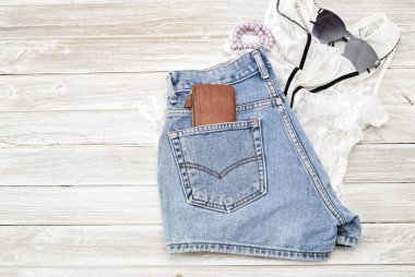 Yaz rahat tarzı. Modern kadın giysi ve aksesuarları kolaj. Güneş gözlüğü, kolsuz bluz ve kot pantolon. Düz yatıyordu, en iyi görünümü