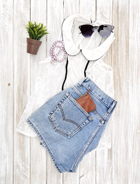 Yaz rahat tarzı. Modern kadın giysi ve aksesuarları kolaj. Güneş gözlüğü, kolsuz bluz ve kot pantolon. Düz yatıyordu, en iyi görünümü