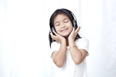 Akıllı telefon ve kulaklık müzik ve dans ile sevimli küçük kız