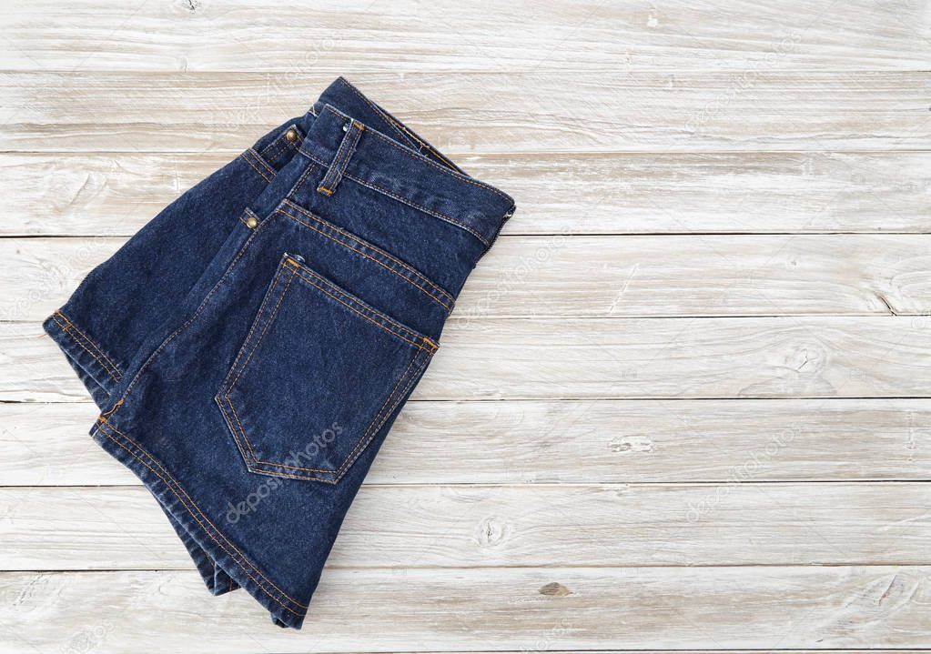 Woman's vintage denim shorts on wooden shelf. shorts from new collection