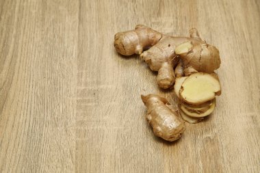 Ham zencefil kökü rustik ahşap masa arka plan üzerine dilimlenmiş