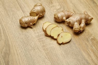 Ham zencefil kökü rustik ahşap masa arka plan üzerine dilimlenmiş