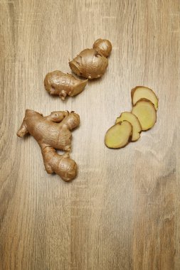 Ham zencefil kökü rustik ahşap masa arka plan üzerine dilimlenmiş