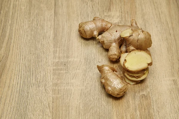 Ham zencefil kökü rustik ahşap masa arka plan üzerine dilimlenmiş