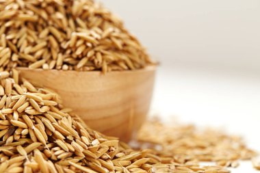 Çeltik tohumu beyaz arka plan üzerinde ahşap kase