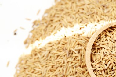 Çeltik tohumu beyaz arka plan üzerinde ahşap kase