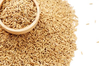 Çeltik tohumu beyaz arka plan üzerinde ahşap kase