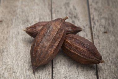 Bir karanlık rustik ahşap masa arka plan üzerine kakao pod