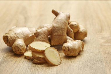 Ham zencefil kökü rustik ahşap masa arka plan üzerine dilimlenmiş