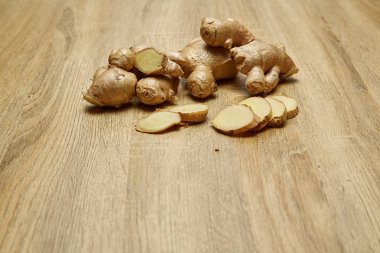 Ham zencefil kökü rustik ahşap masa arka plan üzerine dilimlenmiş