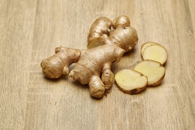 Ham zencefil kökü rustik ahşap masa arka plan üzerine dilimlenmiş