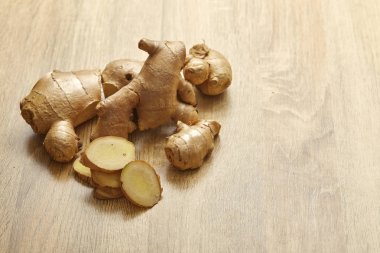 Ham zencefil kökü rustik ahşap masa arka plan üzerine dilimlenmiş