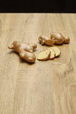 Ham zencefil kökü rustik ahşap masa arka plan üzerine dilimlenmiş