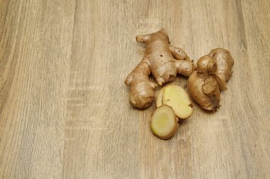 Ham zencefil kökü rustik ahşap masa arka plan üzerine dilimlenmiş