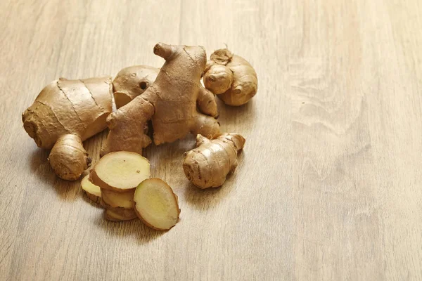 Ham zencefil kökü rustik ahşap masa arka plan üzerine dilimlenmiş