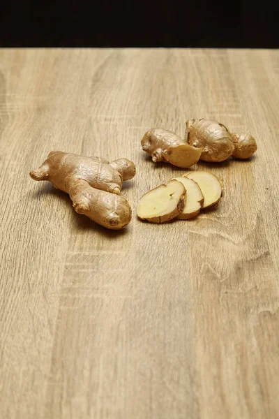 Ham zencefil kökü rustik ahşap masa arka plan üzerine dilimlenmiş