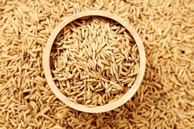 Çeltik tohumu beyaz arka plan üzerinde ahşap kase