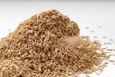 Çeltik tohumu beyaz arka plan üzerinde ahşap kase