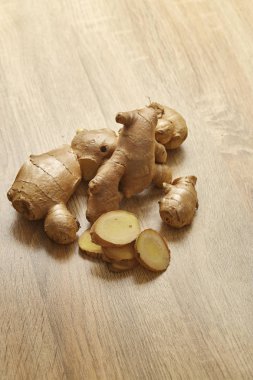 Ham zencefil kökü rustik ahşap masa arka plan üzerine dilimlenmiş