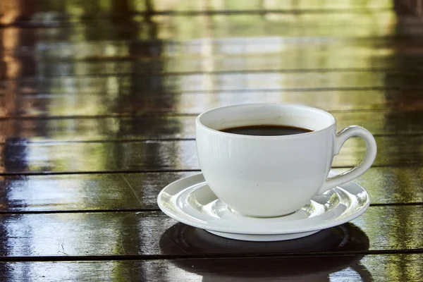 在木制桌子上的杯子里热咖啡 — 图库照片