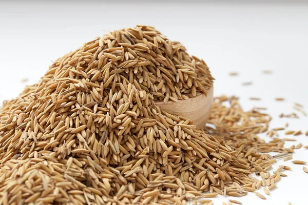 Çeltik tohumu beyaz arka plan üzerinde ahşap kase