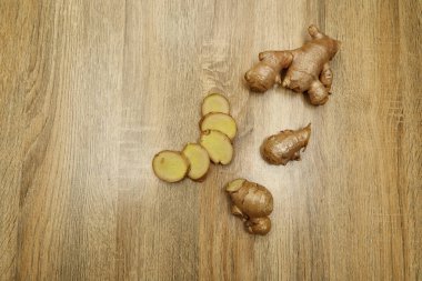 Ham zencefil kökü rustik ahşap masa arka plan üzerine dilimlenmiş