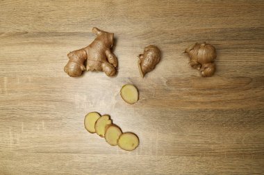 Ham zencefil kökü rustik ahşap masa arka plan üzerine dilimlenmiş