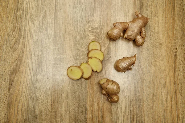 Ham zencefil kökü rustik ahşap masa arka plan üzerine dilimlenmiş