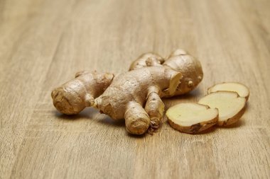 Ham zencefil kökü rustik ahşap masa arka plan üzerine dilimlenmiş