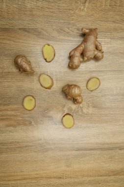 Ham zencefil kökü rustik ahşap masa arka plan üzerine dilimlenmiş