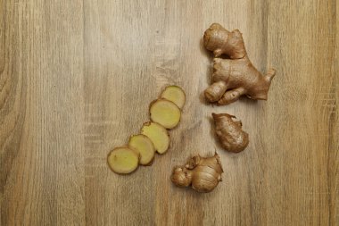 Ham zencefil kökü rustik ahşap masa arka plan üzerine dilimlenmiş