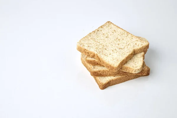 白い背景上に分離されて全体の小麦のパンのスライス — ストック写真