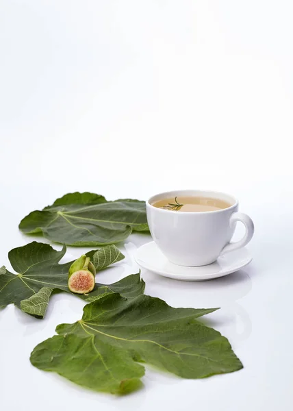 Cup Fig Leaf Tea With rosemary on white background