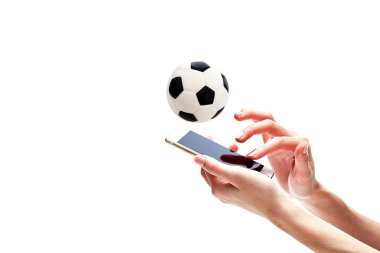Yakın çekim, elini tutarak akıllı telefon karşı futbol topu On Beyaz