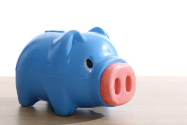 ahşap masa üzerinde plastik mavi kumbara