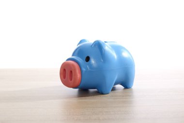 ahşap masa üzerinde plastik mavi kumbara