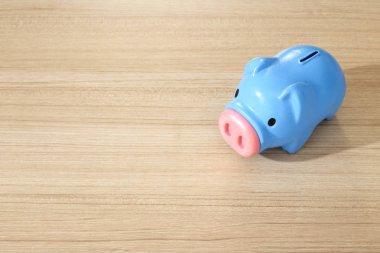 ahşap masa üzerinde plastik mavi kumbara