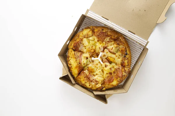 Whole Hawaiian pizza with pineapple and ham in box