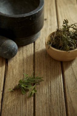 Biberiye ve kekik bölümünü (kurutulmuş, yakın çekim shot) ahşap arka plan üzerinde güneş arka ışık bırakır.