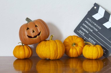 Ahşap masa beyaz duvar arka planda turuncu halloween balkabağı.