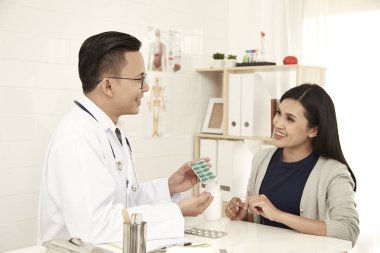 Genç bir anne onun doktor ofisinde bir doktor konuşuyor. o bir beyaz tıbbi elbisesi, Aile planlaması kavramı giyinmiş