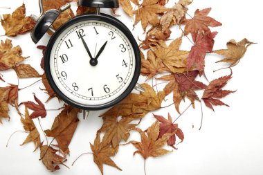 Sonbahar zaman değişiklik görüntüsünü, Güz geri kavramı, kuru yapraklar ve vintage siyah saat ahşap masa üzerinde açık havada, öğleden sonra metin için alarm