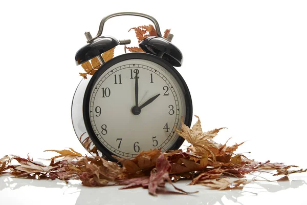 秋の時間変化の画像 秋バック コンセプト 乾燥葉 ヴィンテージ時計ブラック木製テーブルの上屋外本文の午後 ストック画像