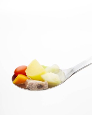 Beyaz arka plan, açlık kavramı kaşık üzerinde sebze domuz eti kemik çorbası